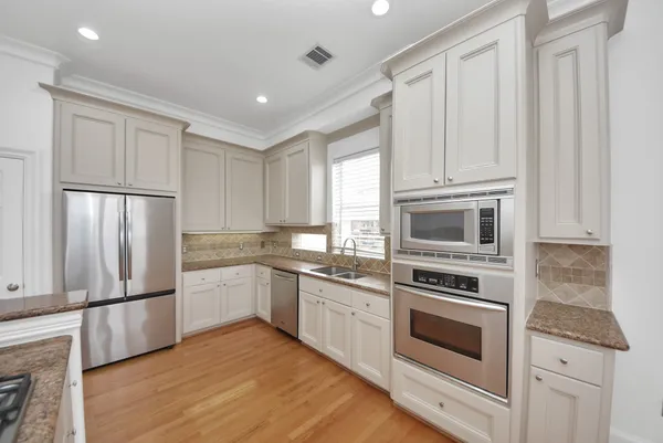 a kitchen with granite countertop a refrigerator stove and microwave