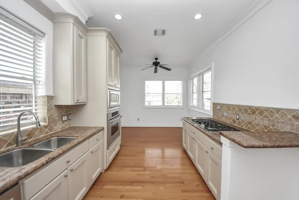 a kitchen with stainless steel appliances granite countertop a sink stove and cabinets