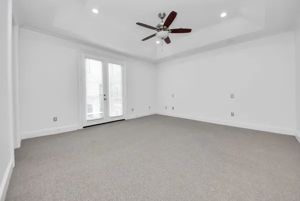 an empty room with a ceiling fan and window
