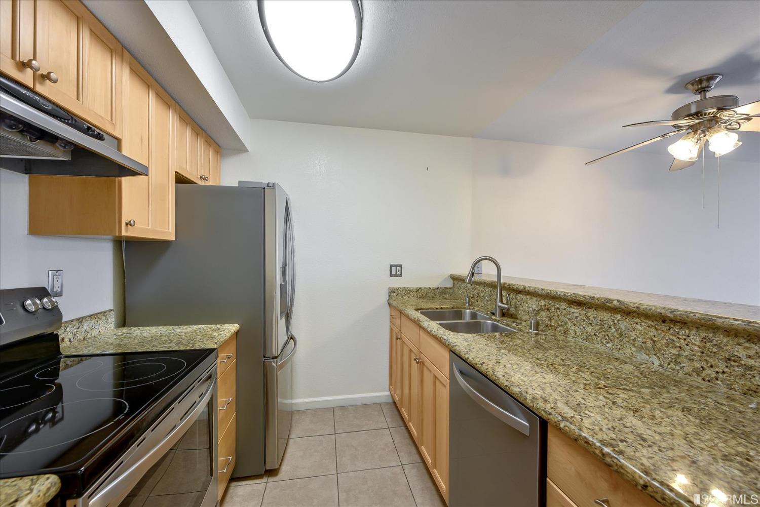 466 Crescent Street, Unit 310 Oakland, CA 94610 - Photo 11 of 24 a kitchen with a granite countertop sink a stove and a refrigerator