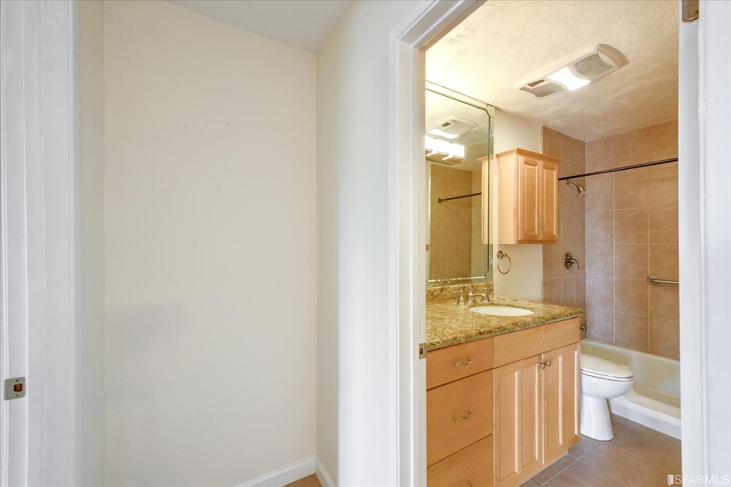 466 Crescent Street, Unit 310 Oakland, CA 94610 - Photo 17 of 24 a bathroom with a granite countertop sink toilet and shower
