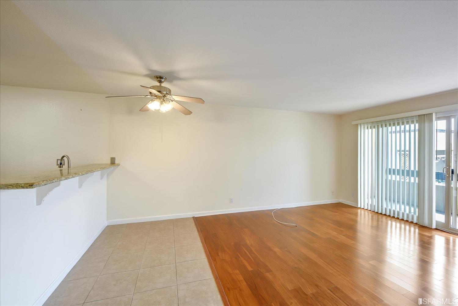 466 Crescent Street, Unit 310 Oakland, CA 94610 - Photo 5 of 24 a view of a room with wooden floor and a ceiling fan