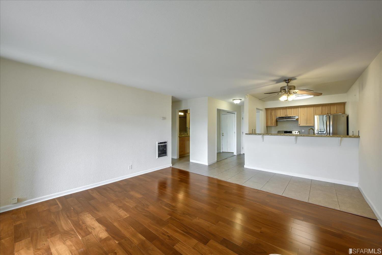 466 Crescent Street, Unit 310 Oakland, CA 94610 - Photo 8 of 24 a view of a big room with wooden floor and a kitchen