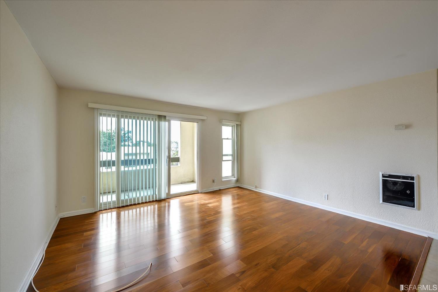 466 Crescent Street, Unit 310 Oakland, CA 94610 - Photo 9 of 24 a view of an empty room with wooden floor and a window
