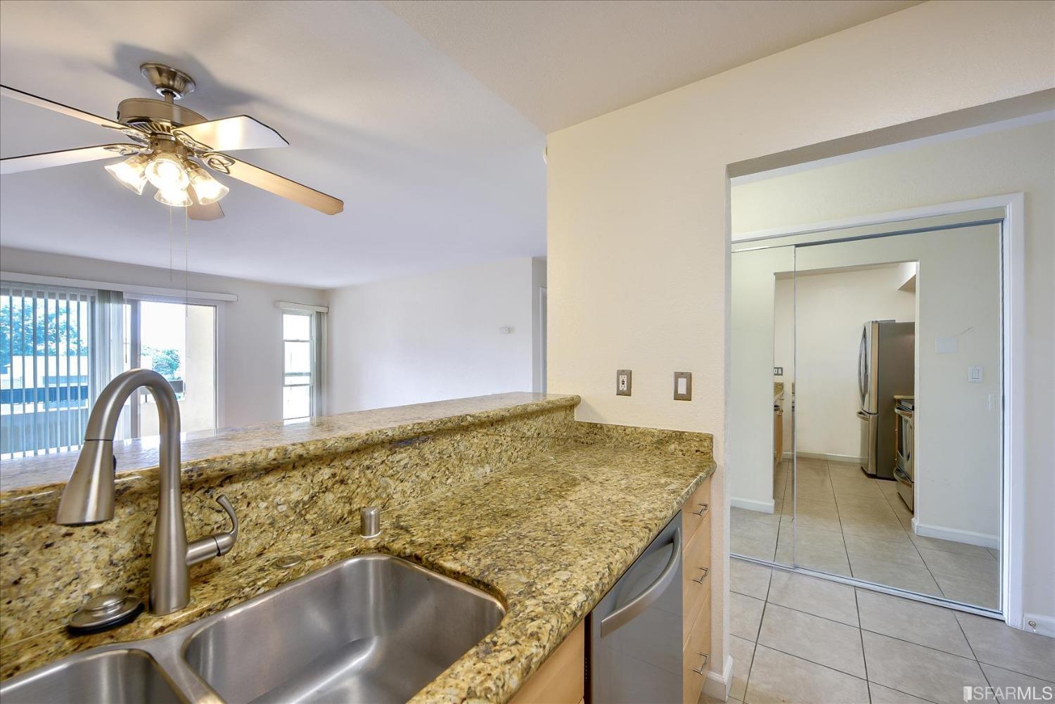 466 Crescent Street, Unit 310 Oakland, CA 94610 - Photo 10 of 24 a bathroom with a granite countertop sink a window and a mirror