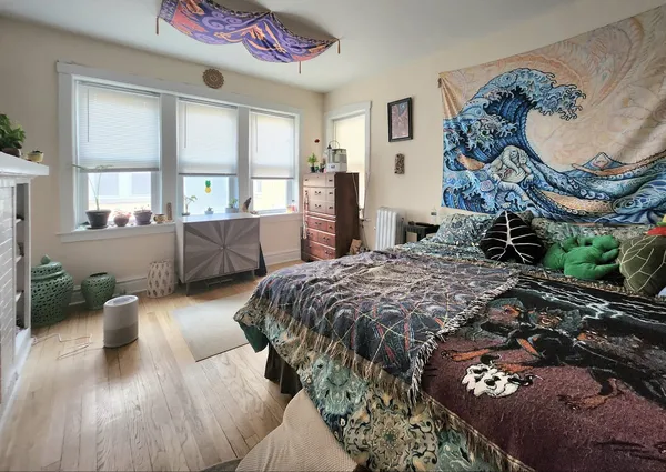a bed sitting in a spacious bedroom next to a window