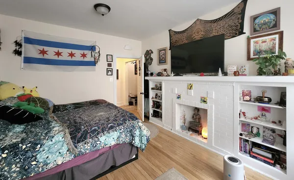 a bedroom with a bed a flat screen tv and dresser