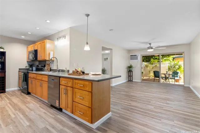 a kitchen with stainless steel appliances granite countertop a sink a stove and a wooden floors
