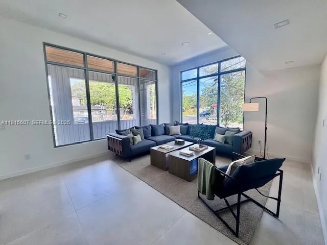 a living room with furniture and a floor to ceiling window