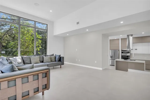 a living room with furniture and large windows