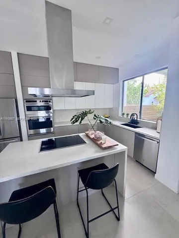 a kitchen with a sink a stove and chairs