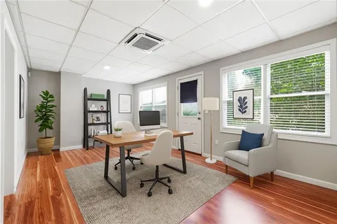 a work room with furniture wooden floor and a window