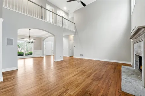 a view of empty room with wooden floor and fireplace