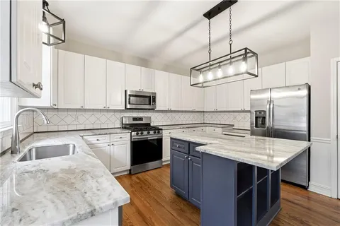 a kitchen with stainless steel appliances granite countertop a sink stove and refrigerator