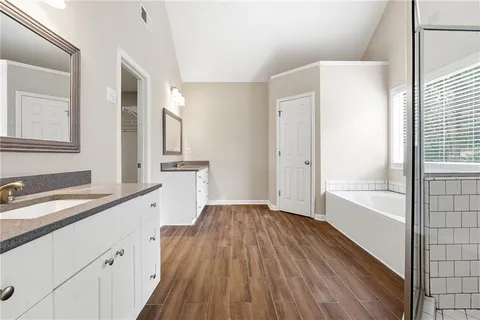 a bathroom with a sink a large mirror and shower
