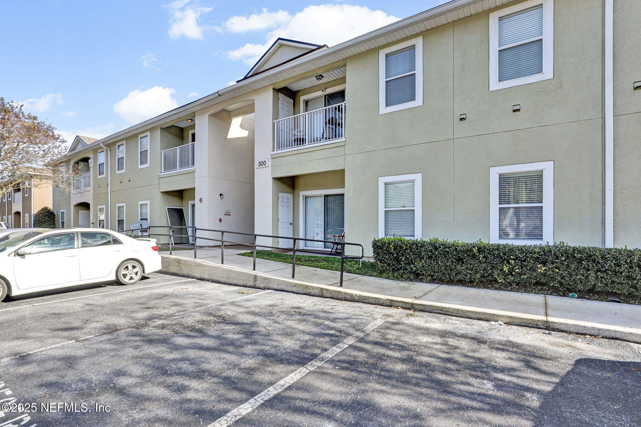 7920 Merrill Road, Unit 305 Jacksonville, FL 32277 - Photo 2 of 12 a view of building with large windows and pathway