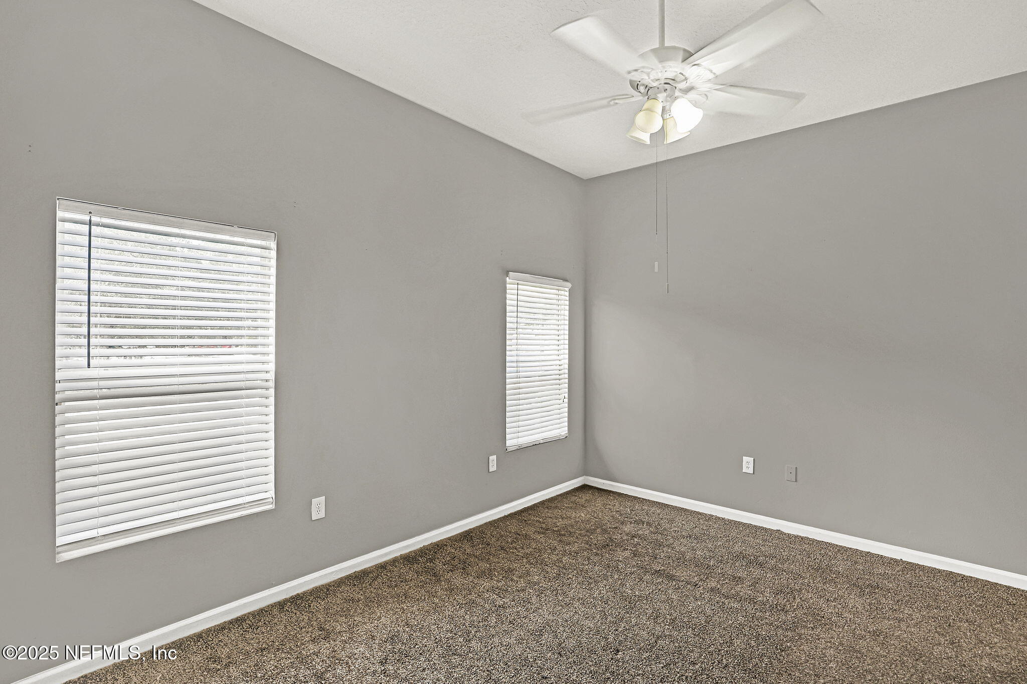 7920 Merrill Road, Unit 305 Jacksonville, FL 32277 - Photo 8 of 12 an empty room with windows and fan