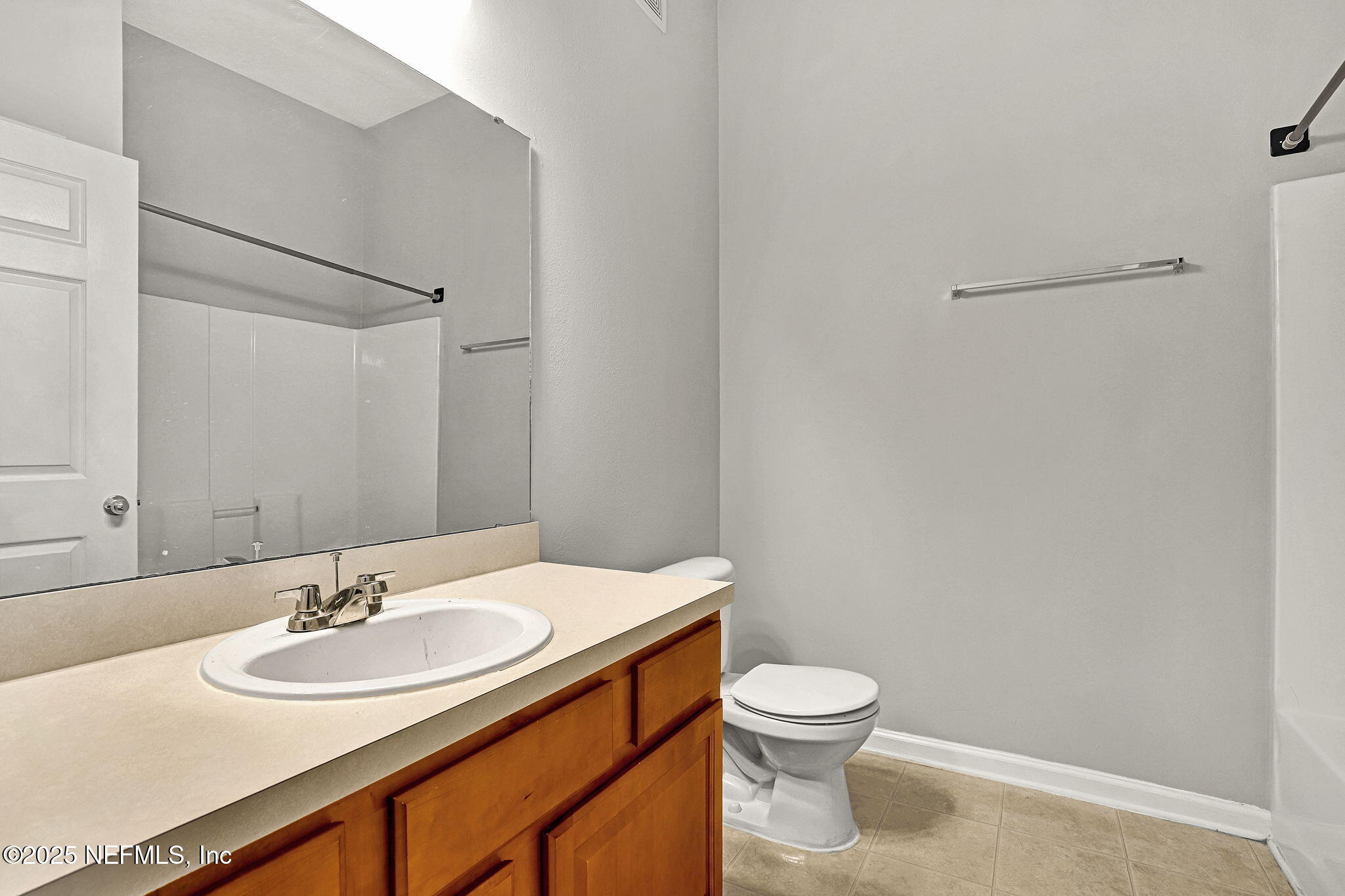 7920 Merrill Road, Unit 305 Jacksonville, FL 32277 - Photo 10 of 12 a bathroom with a sink a toilet and a mirror