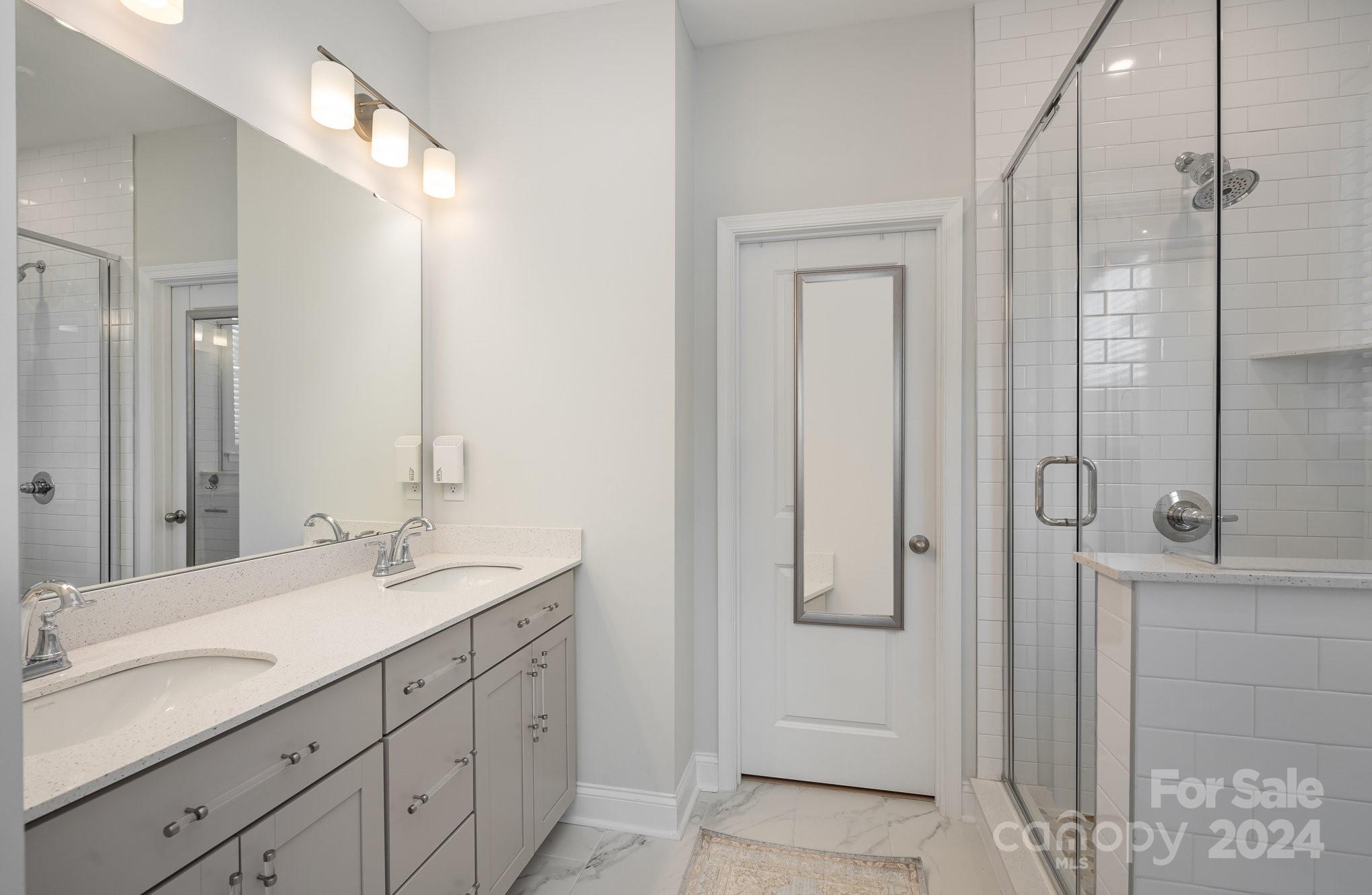 3063 Patchwork Court Fort Mill, SC 29708 - Photo 17 of 28 a bathroom with a double vanity sink and mirror