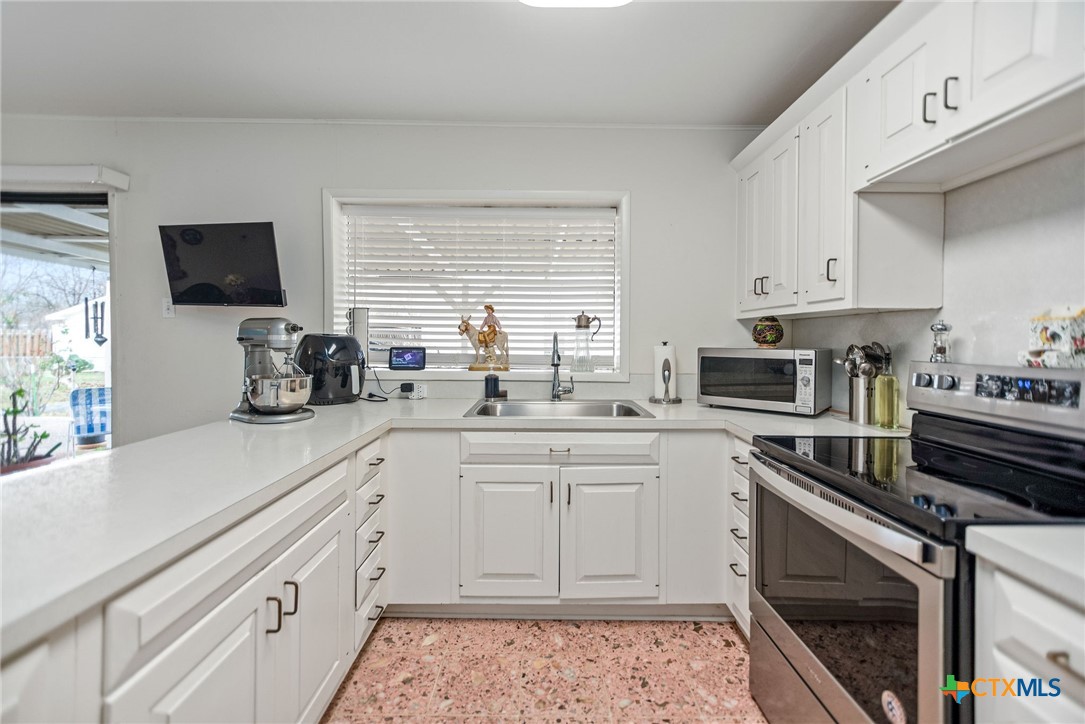207 Williams Street Tivoli, TX 77990 - Photo 14 of 32 a kitchen with a sink stove and microwave