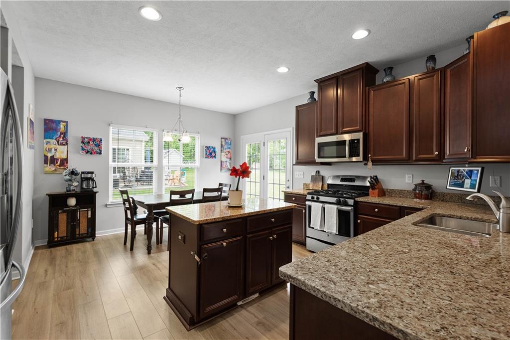 5018 Firwood Drive Canonsburg, PA 15317 - Photo 13 of 50 a kitchen with granite countertop a stove top oven a sink dishwasher a dining table and chairs with wooden floor