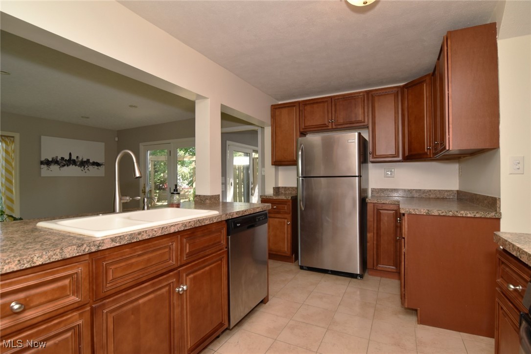 3679 Fenley Road Cleveland Heights, OH 44121 - Photo 14 of 45 Kitchen with stainless steel appliances, brown cabinetry, and light tile patterned floors