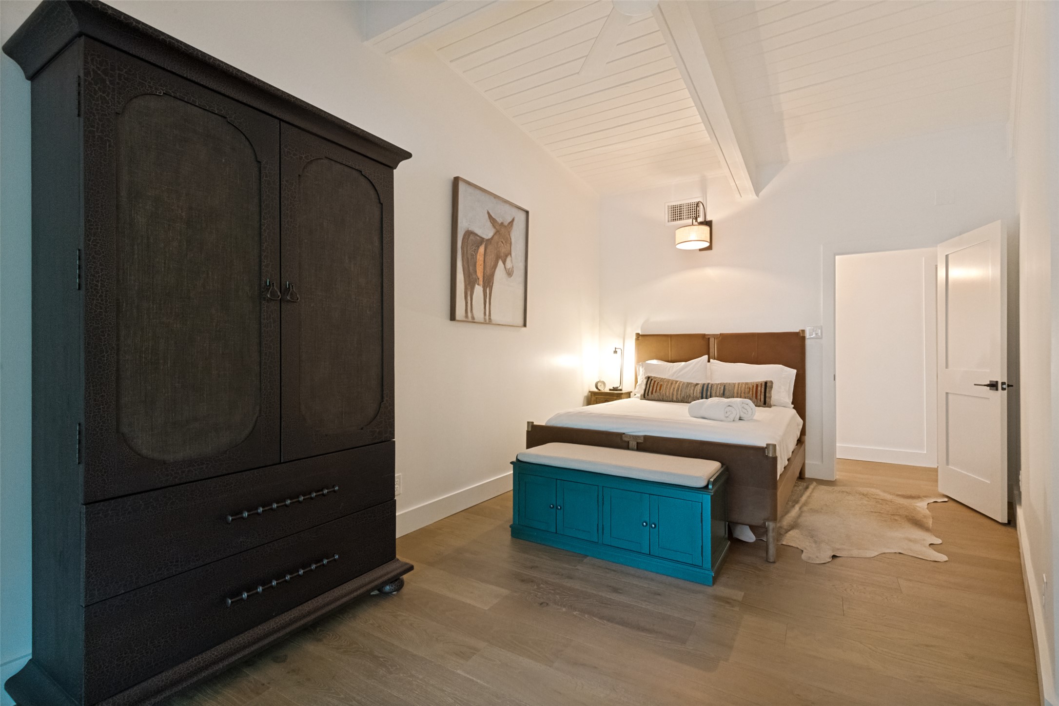 303 Lago Verde Road Austin, TX 78734 - Photo 24 of 39 Slanted ceiling and wide plank hardwood flooring define this comfortable sleeping area.
