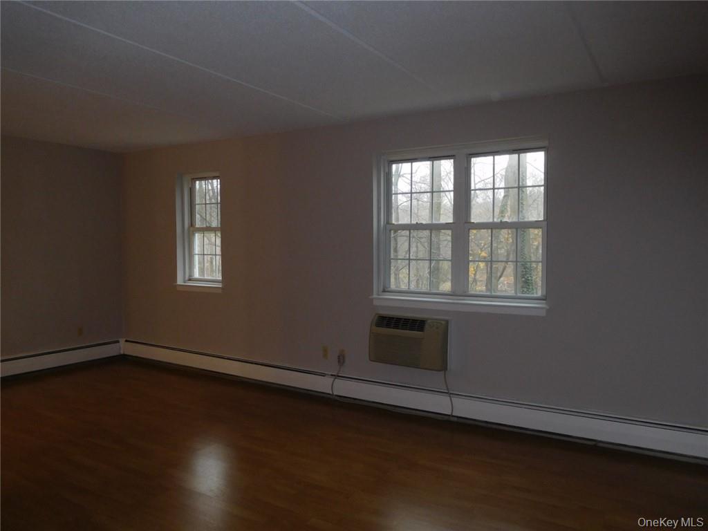 4 Consulate Drive, Unit 1M Tuckahoe, NY 10707 - Photo 13 of 17 an empty room with wooden floor and windows