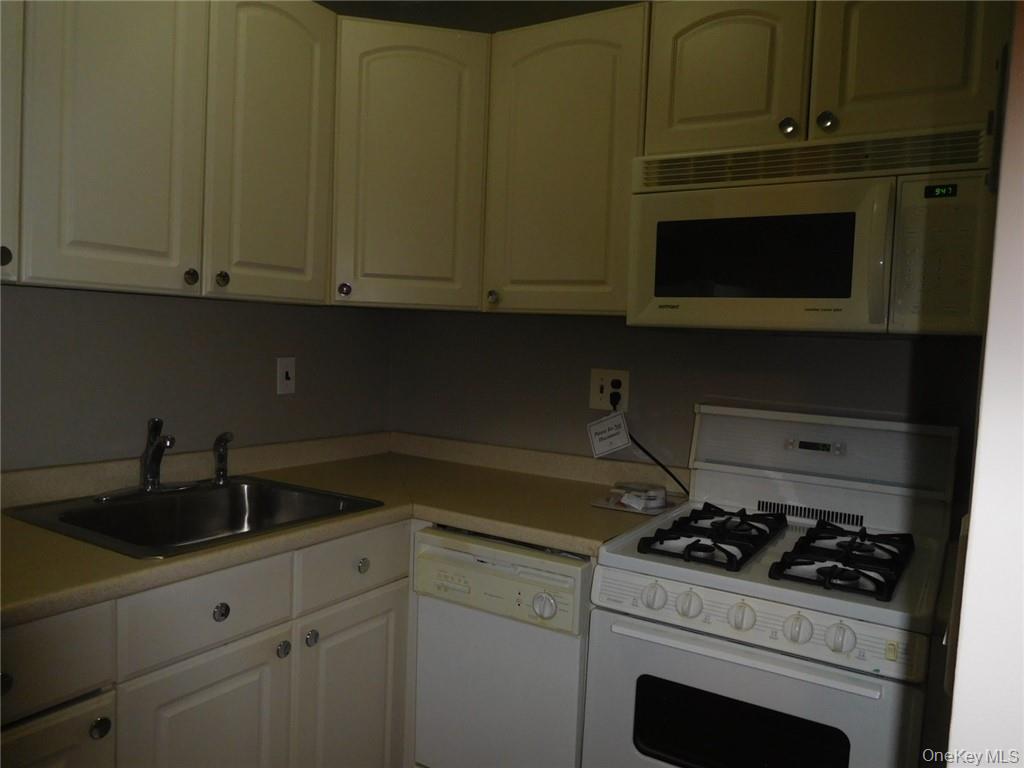4 Consulate Drive, Unit 1M Tuckahoe, NY 10707 - Photo 7 of 17 a kitchen with granite countertop cabinets and white stove