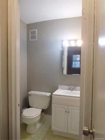 a bathroom with a toilet a sink and mirror