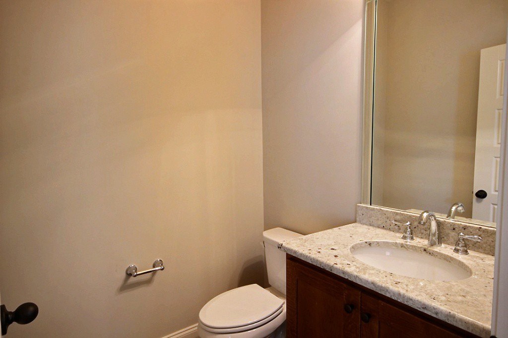 186 East South Street, Unit 1 Collierville, TN 38017 - Photo 13 of 22 a bathroom with a granite countertop sink a toilet and mirror