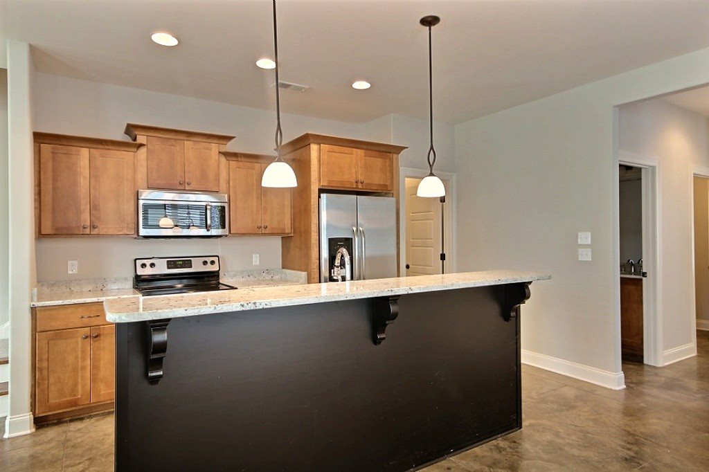 186 East South Street, Unit 1 Collierville, TN 38017 - Photo 7 of 22 a kitchen with stainless steel appliances granite countertop a sink a stove and a wooden floor