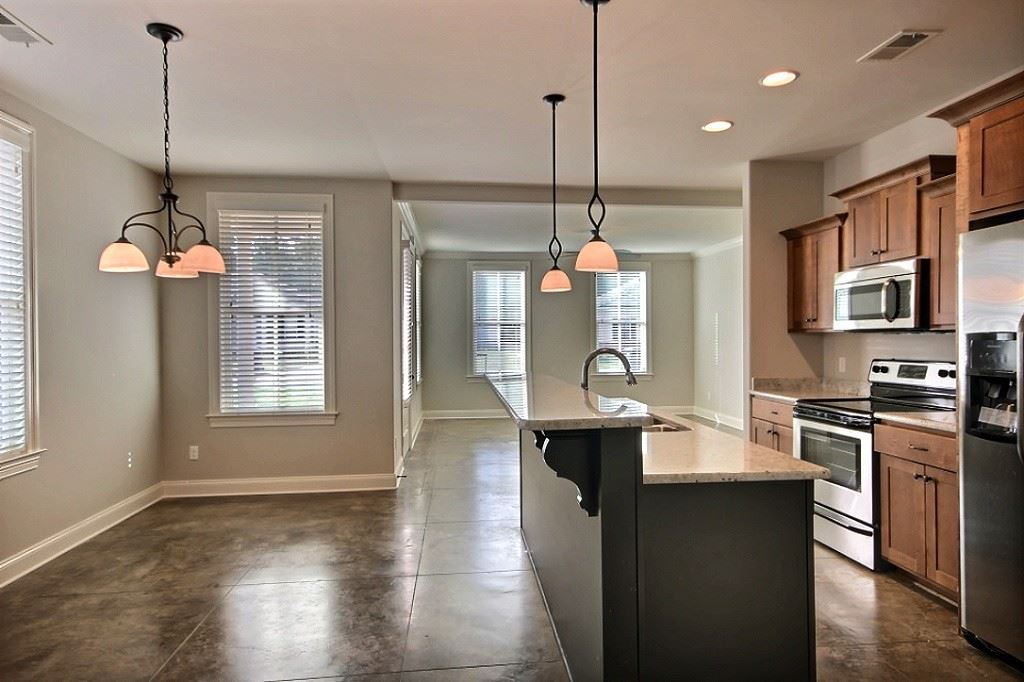 186 East South Street, Unit 1 Collierville, TN 38017 - Photo 8 of 22 a kitchen with stainless steel appliances granite countertop a stove a sink a refrigerator a center island a dining table and chairs