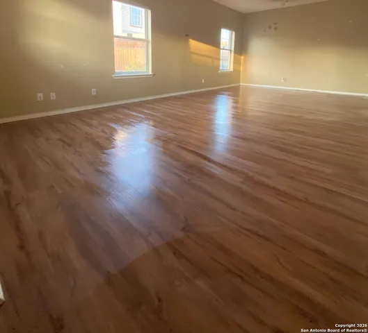 wooden floor in an empty room with a window