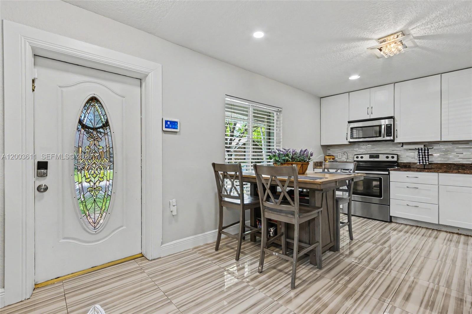 7941 Northwest 3rd Place Plantation, FL 33324 - Photo 21 of 51 a kitchen with stainless steel appliances a dining table chairs stove and refrigerator