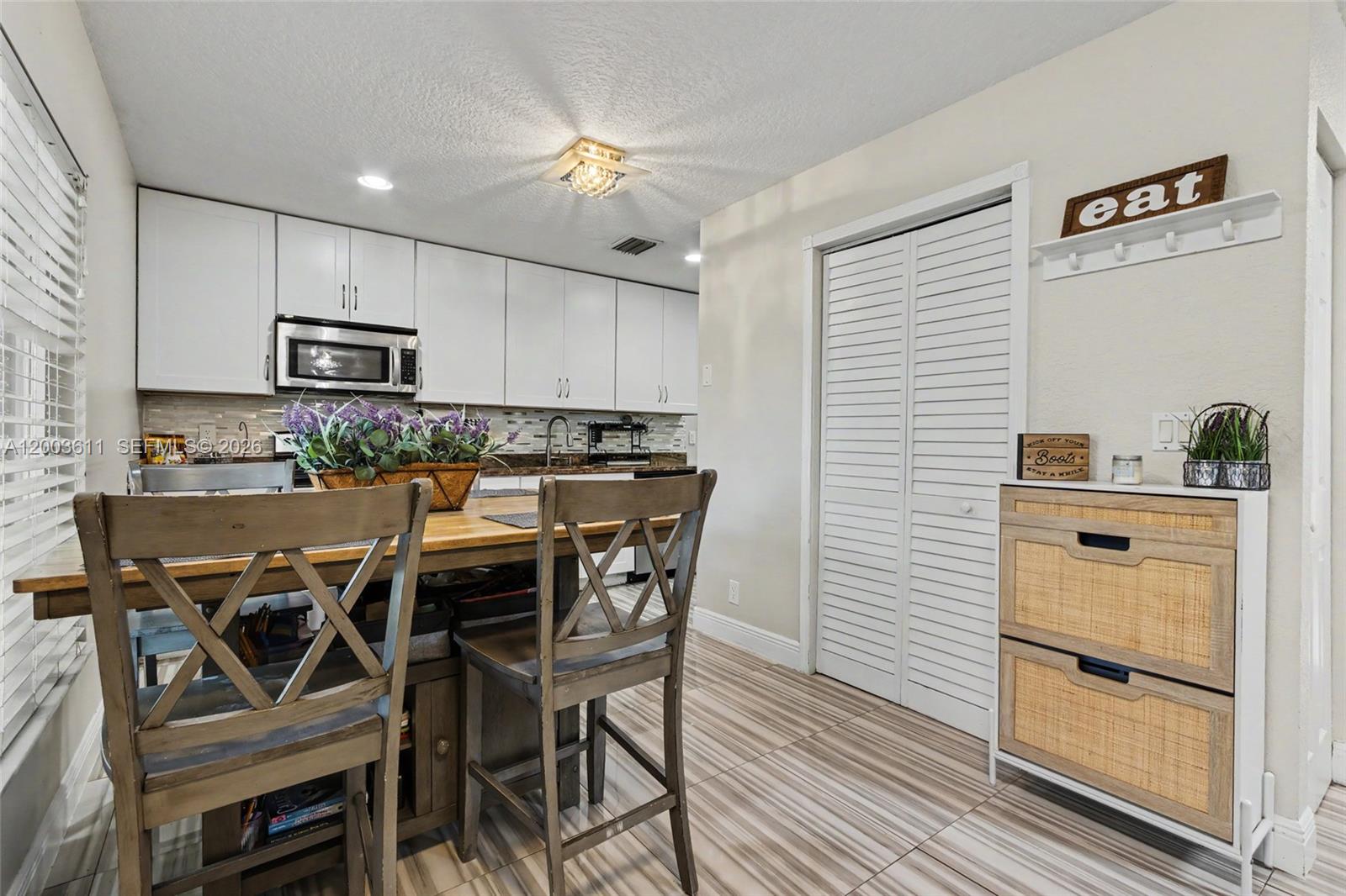 7941 Northwest 3rd Place Plantation, FL 33324 - Photo 22 of 51 a kitchen with stainless steel appliances kitchen island granite countertop a table chairs sink and cabinets