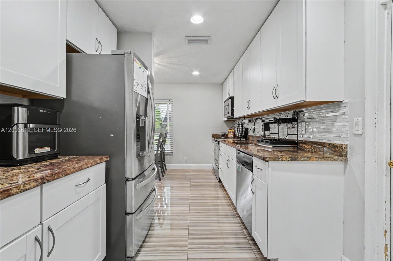 7941 Northwest 3rd Place Plantation, FL 33324 - Photo 25 of 51 a kitchen with stainless steel appliances granite countertop a sink and a stove