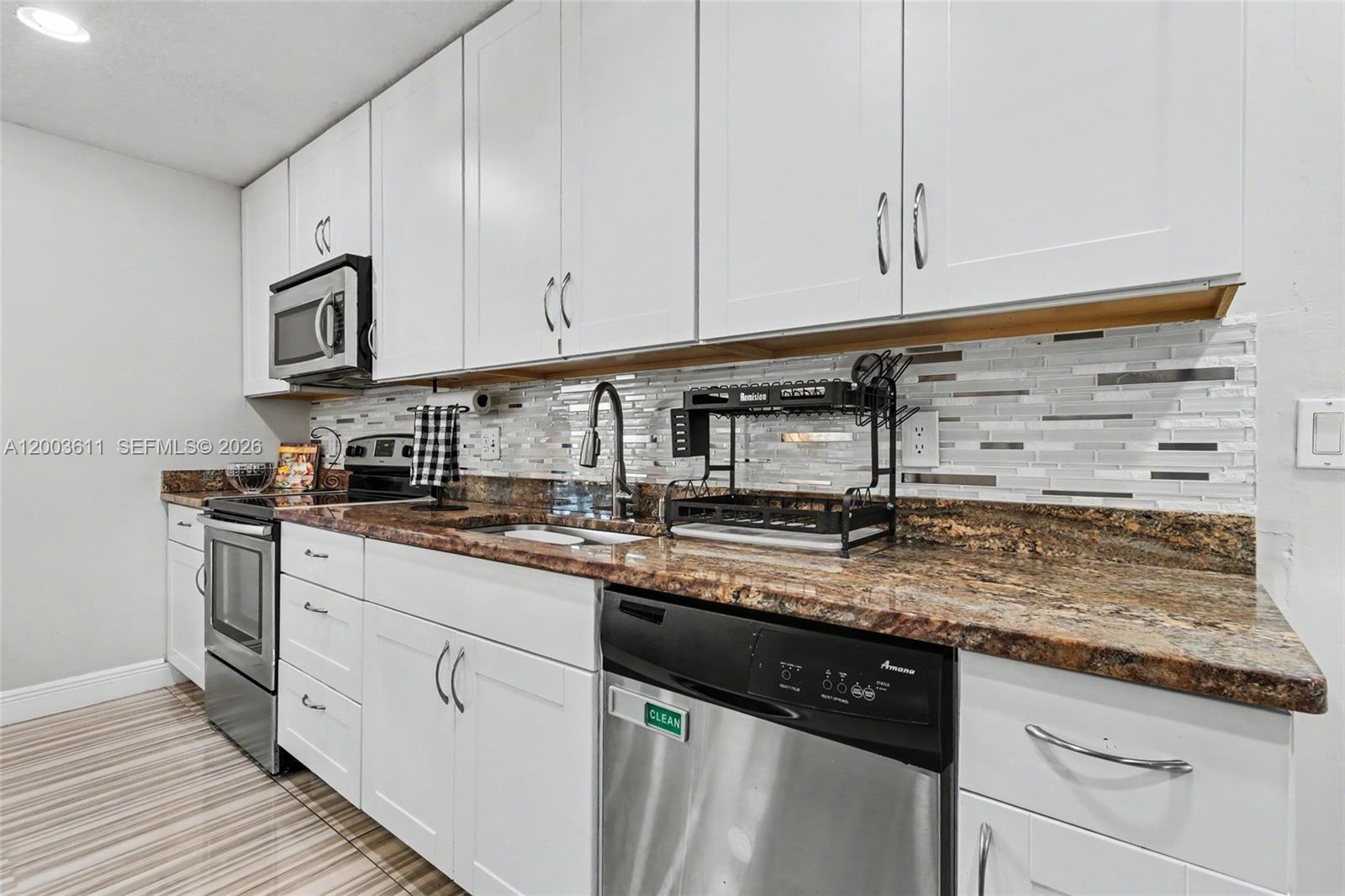 7941 Northwest 3rd Place Plantation, FL 33324 - Photo 26 of 51 a kitchen with stainless steel appliances granite countertop a sink a stove and cabinets