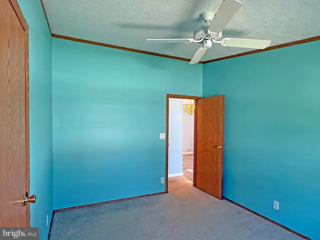 an empty room with a chandelier fan and closet