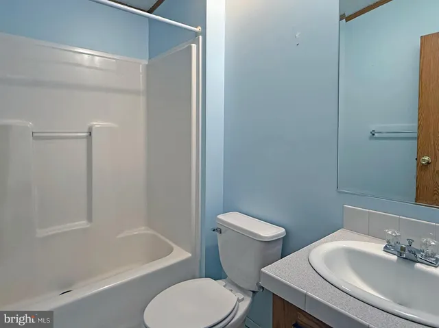 a white toilet sitting next to a bath tub