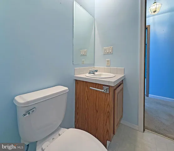 a bathroom with a toilet a sink and mirror