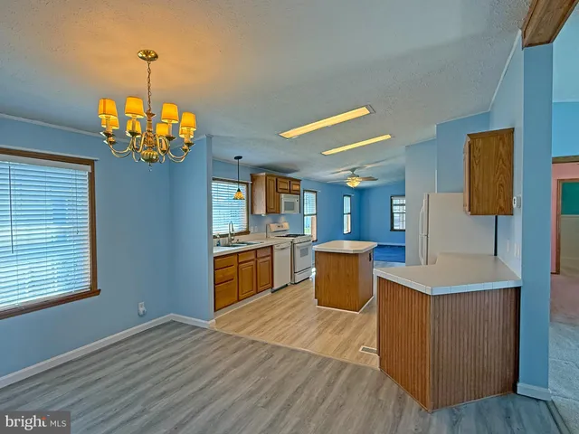 a kitchen with a sink wooden floor and a refrigerator