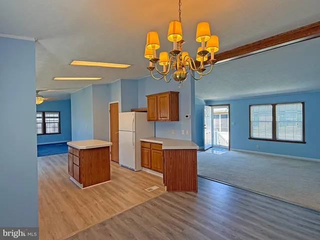a dining room filled chandelier and wooden floor