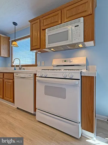 a kitchen with granite countertop cabinets stainless steel appliances and a wooden floor