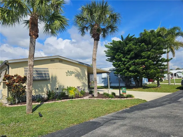 a view of a fountain in front of a house with a big yard