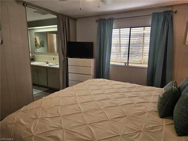 a bedroom with a bed and a flat tv screen