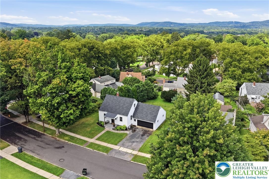 408 Maple Road Hellertown, PA 18055 - Photo 59 of 66 Lush green trees frame this charming neighborhood view with mountains rising on the horizon.