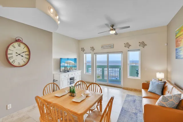 a living room with furniture a large window and a chandelier