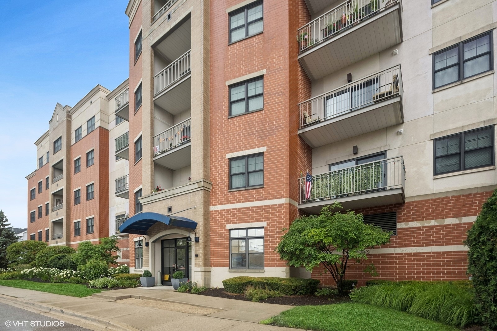 a front view of a multi story residential apartment building with yard