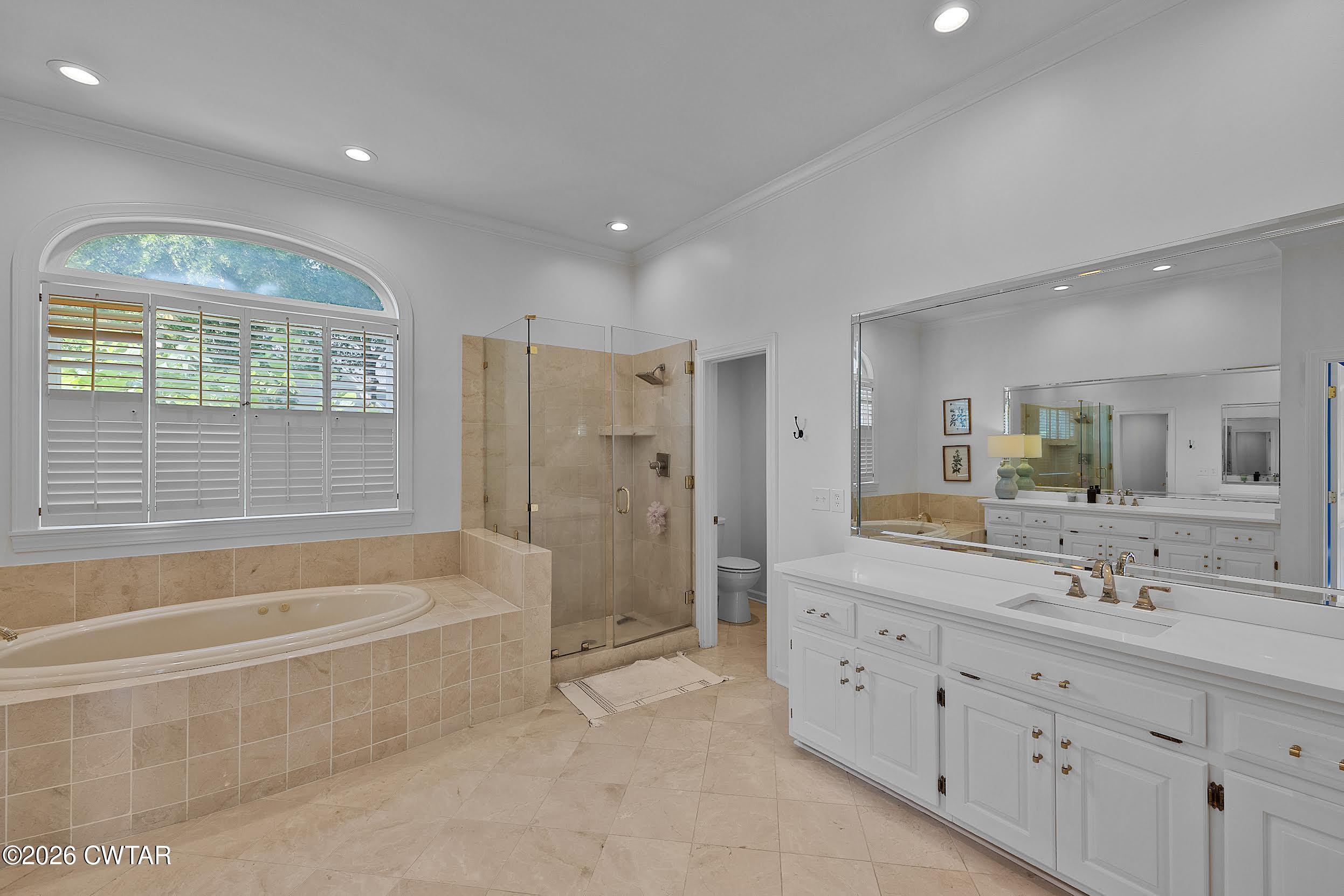 58 Huntington Place Jackson, TN 38305 - Photo 32 of 38 a spacious bathroom with bathtub double vanity shower and a double vanity sink mirror